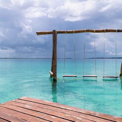 Beautiful view of wooden swings in the Bacalar Lagoon in Mexico.